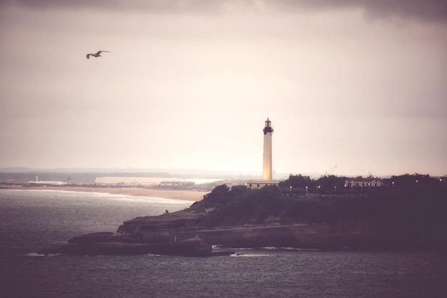 Photo phare par la mer contre le ciel