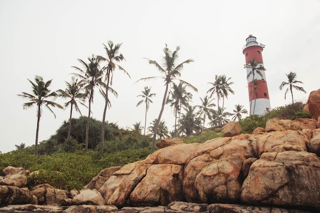 Phare sur la plage au ciel dramatique du matin à Kovalam Kerala Inde