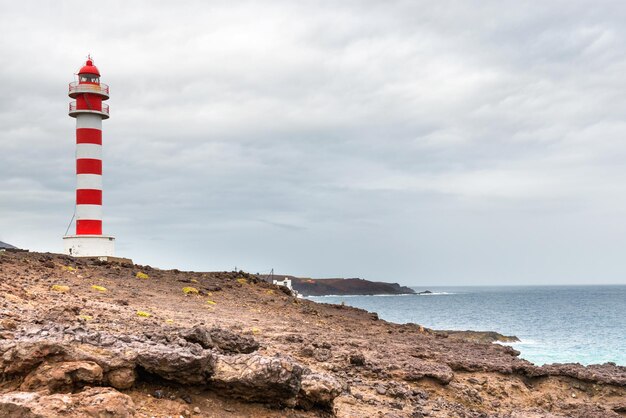 Phare rayé rouge et blanc sur la côte rocheuse de l'île de Gran Canaria Espagne