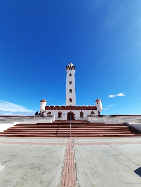 un phare se tient sur le toit d'un bâtiment avec un fond de ciel