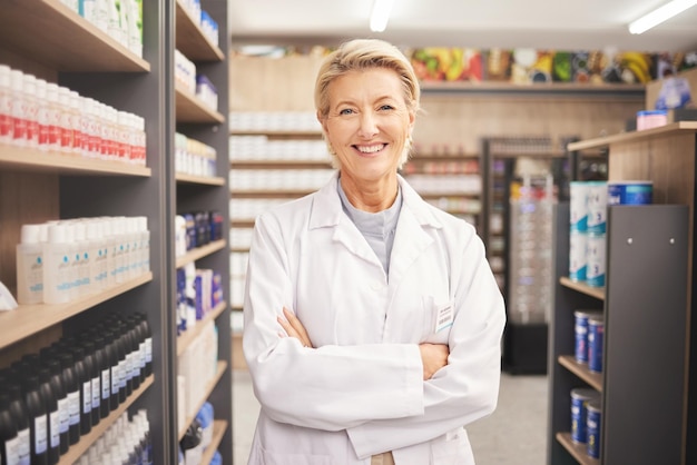 Pharmacie senior femme pharmacien en portrait à la pharmacie et pilules avec des médicaments pour les soins de santé Médicaments santé et bras croisés pharmaceutique et heureux avec une professionnelle de la santé confiante