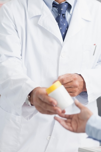 Pharmacien donnant une boîte de pilules à quelqu&#39;un