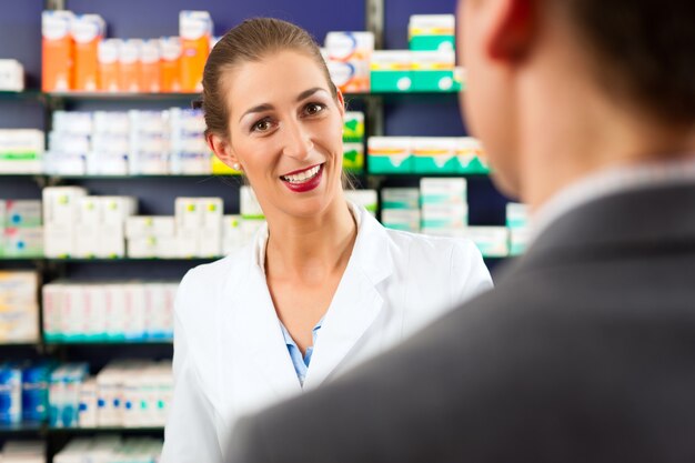 Pharmacien femme avec un client en pharmacie