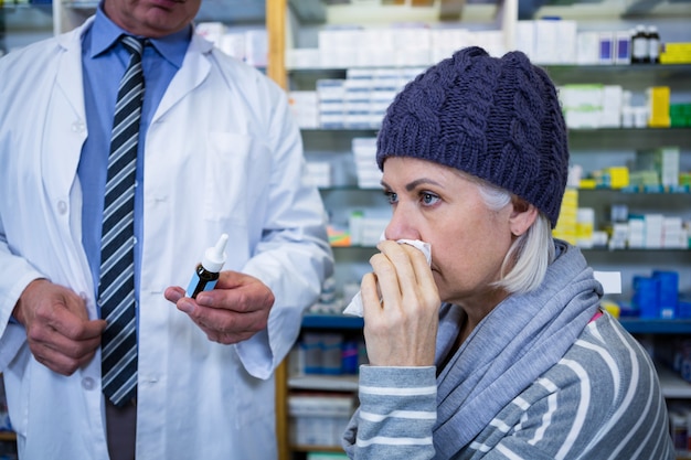 Pharmacien montrant des médicaments au client