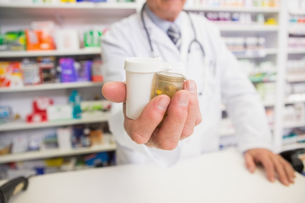 Pharmacien présentant des médicaments sur sa main