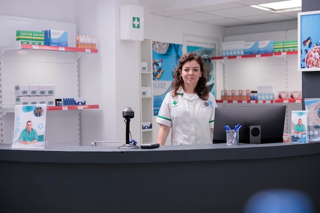 Pharmacien en uniforme médical debout au comptoir de la pharmacie, travaillant avec la prescription pharmaceutique du client. Ouvrier en pharmacie vendant des suppléments, des vitamines pour un mode de vie sain. Soutien médical