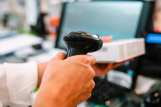 Photo le pharmacien utilise un lecteur de code-barres pour identifier et vendre un médicament