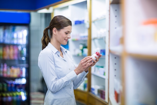 Pharmacien vérifiant une bouteille de médicament