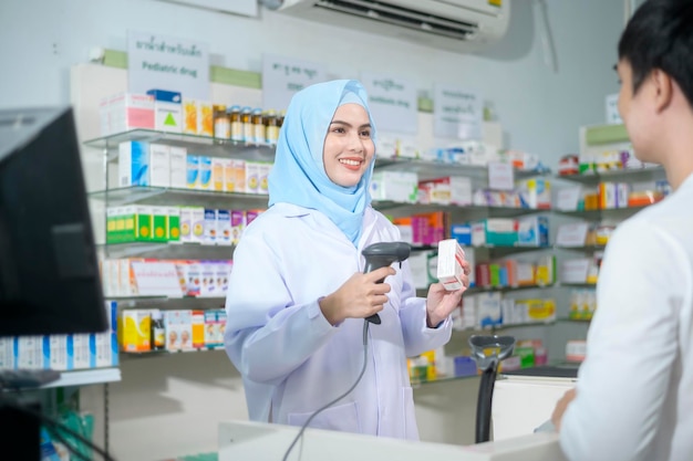 Une pharmacienne musulmane conseille un client sur l'utilisation de médicaments dans une pharmacie moderne