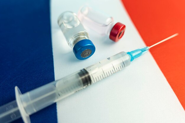 Pharmacologie et médecine France concept vaccin contre le coronavirus covid industrie pharmacologique nationale Ampoules de vaccin seringue sur fond de drapeau national