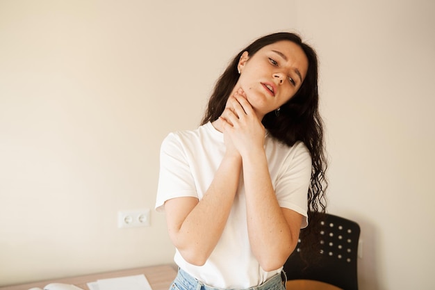 Pharyngite premiers symptômes mal de gorge Sick jolie fille touche la gorge avec douleur Médecine des maladies saisonnières