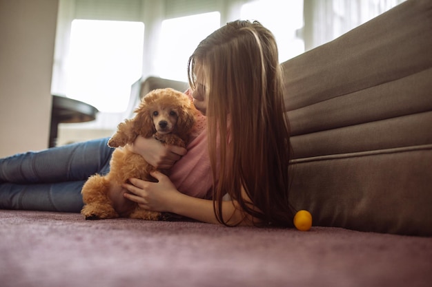 Photo d'un adolescent allongé sur le sol avec un chiot