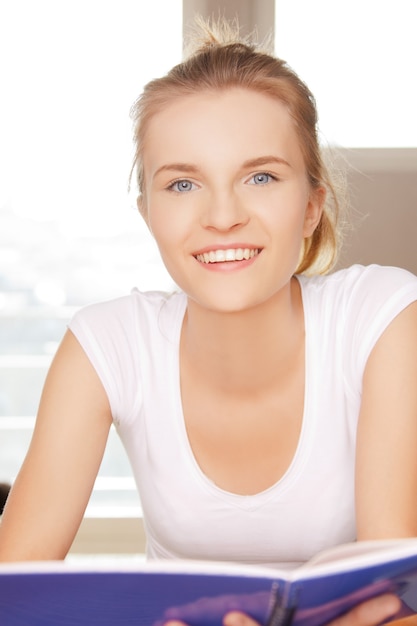 Photo photo d'une adolescente heureuse et souriante avec un grand bloc-notes