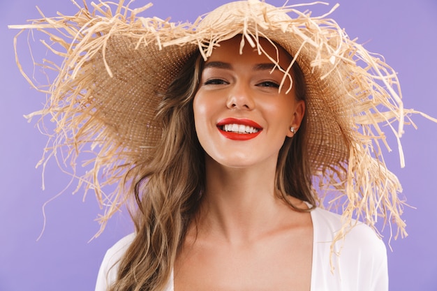 Photo d'adorable jeune femme portant robe et grand chapeau de paille souriant