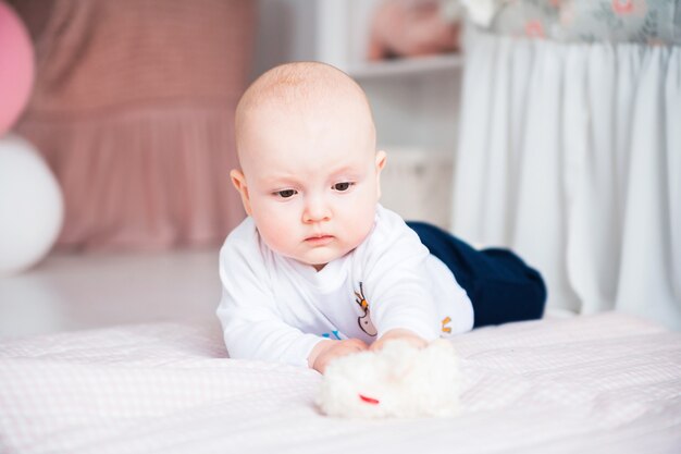 Photo d'adorable petit garçon allongé sur le sol dans sa chambre d'enfant et jouer avec des jouets