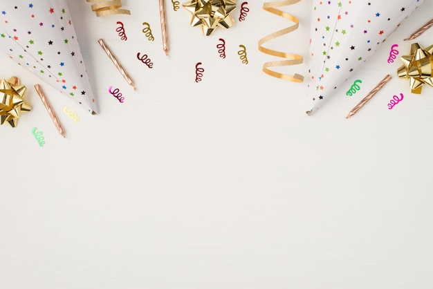 Photo aérienne de l'arc de confettis bougies et chapeau d'anniversaire isolé sur fond blanc avec espace vide