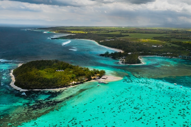 Photo aérienne de la côte est de l'île Maurice. Belle lagune de l'île Maurice prise d'en haut. Bateau naviguant dans le lagon turquoise