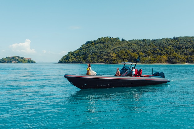 Photo aérienne de drone de bateau à moteur gonflable naviguant à grande vitesse dans une mer tropicale d'eau claire émeraude