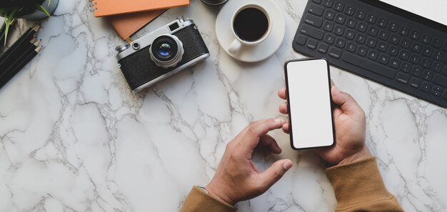 Photo Aérienne Du Photographe Professionnel Tenant Un Smartphone Avec Un écran Blanc Dans Un Style