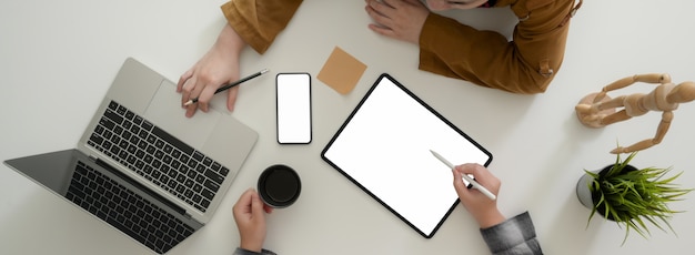 Photo aérienne de gens d'affaires consultant sur leur stratégie commerciale sur tableau blanc