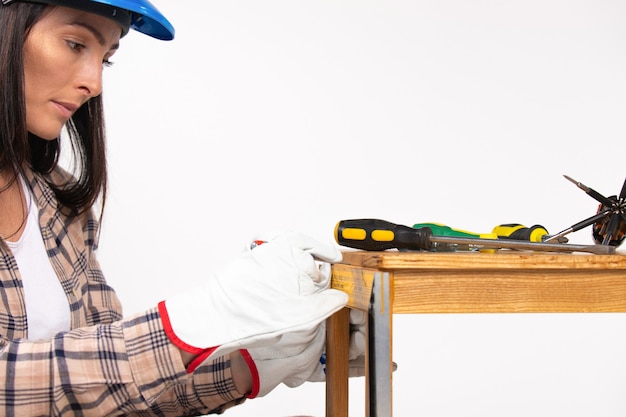 Photo agrandie de femme travailleur de la construction réparant un tabouret avec des tournevis fond isolé blanc