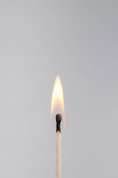 Photo d'une allumette brûlante sur fond clair avec feu