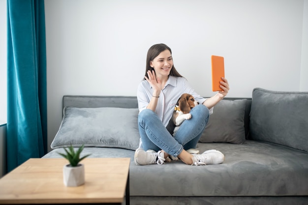 Photo avec un ami. Une jolie jeune femme faisant un selfie avec son chiot