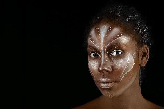 Photo d'art d'une femme africaine avec des peintures ethniques tribales sur son visage