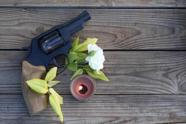 photo d'art. vintage still life with gun et rose sur fond de bois