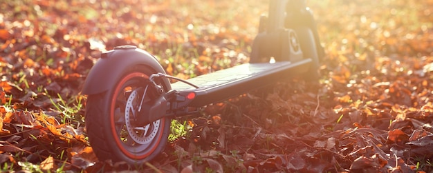 Photo photo d'automne du coucher du soleil avec scooter électrique ou escooter transport urbain écologique pour le transport urbain