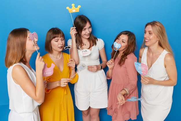 La photo avant d'un groupe de femmes joyeuses d'avoir le sexe révèle un arrière-plan bleu isolé