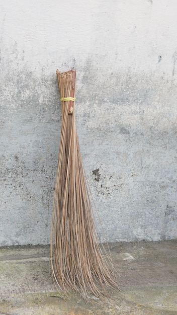 photo d'un balai en fibre de palmier et d'un mur