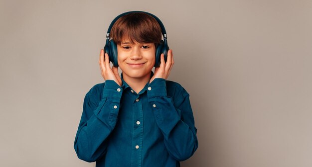 Photo de bannière d'un mignon adolescent souriant portant des écouteurs et écoutant de la musique