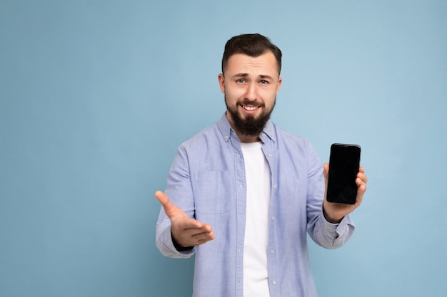 Photo de beau beau jeune homme mal rasé brune avec barbe portant un t-shirt blanc décontracté