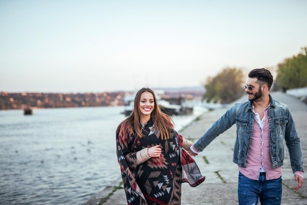 Photo d'un beau couple marchant et s'amusant dehors