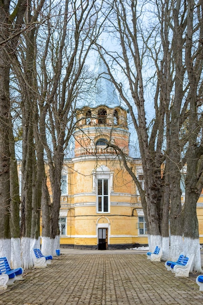 Photo d'un beau vieux bâtiment rétro derrière une petite allée de parc avec des bancs