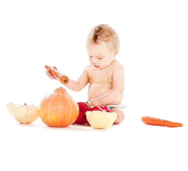 Photo de bébé garçon en couche avec des légumes