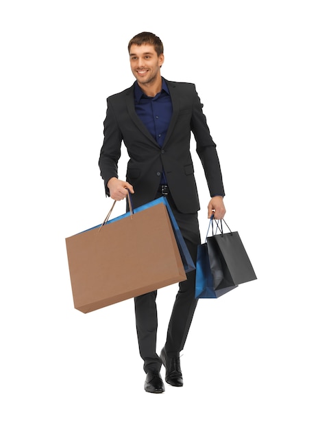 photo de bel homme en costume avec des sacs à provisions.