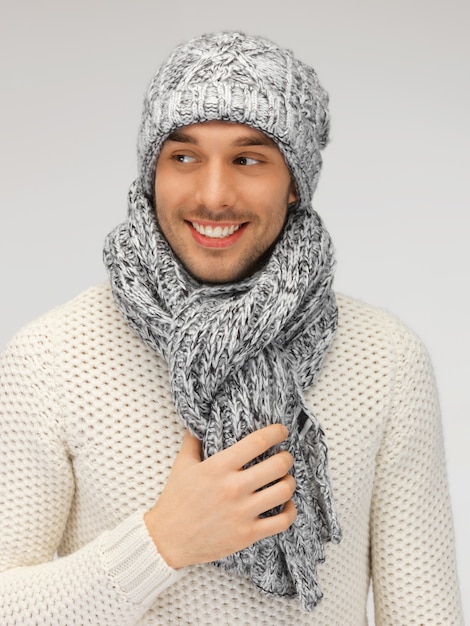 photo d'un bel homme en pull chaud, bonnet et écharpe.