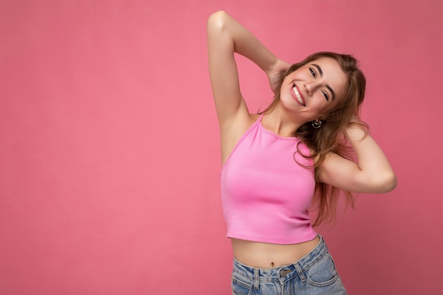 Photo de belle femme adulte souriante positive portant des vêtements élégants debout isolé sur un mur coloré avec espace de copie.