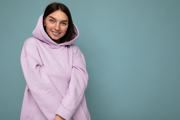 Photo d'une belle femme adulte souriante et positive portant des vêtements élégants, isolée sur fond coloré avec espace de copie en regardant la caméra.