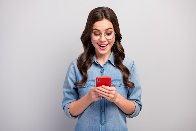 Photo de belle femme d'affaires indépendant en attente de navigation téléphone chèque abonnés abonnés addicted usure des spécifications de l'usure des jeans occasionnels chemise en jean couleur gris isolé