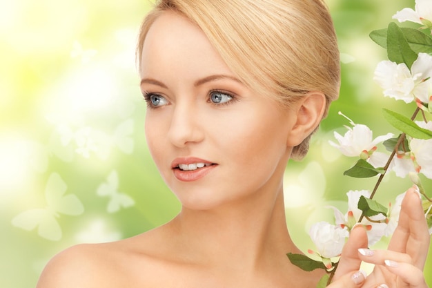 photo de belle femme avec des fleurs sur des brindilles