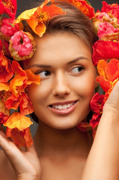 photo de belle femme avec des fleurs rouges