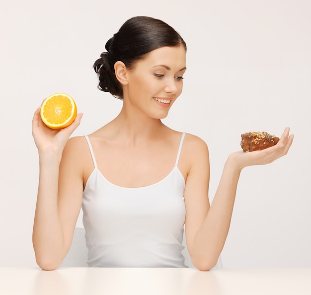 photo de belle femme avec gâteau et orange