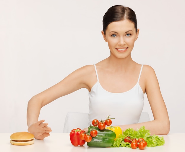 photo de belle femme avec hamburger et légumes