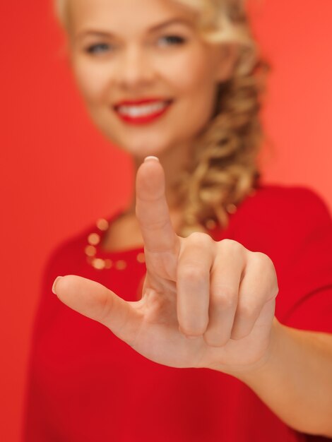 photo de belle femme en robe rouge appuyant sur le bouton virtuel