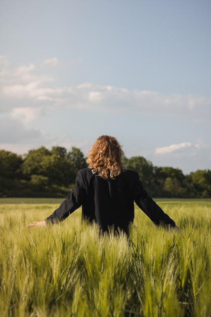 Photo d'une belle fille aux cheveux rouges dans un champ. La fille est vêtue d'un costume d'homme. Été, champ, nature.