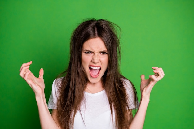 Photo de belle fille en colère habillée en tenue décontractée ont les cheveux en mauvais état les bras en arrière-plan de couleur vert isolé