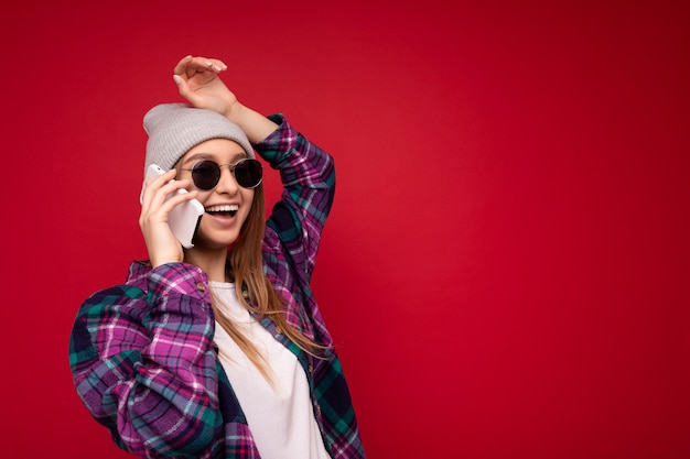 Photo d'une belle jeune femme blonde positive et heureuse portant une chemise violette hipster et un blanc décontracté